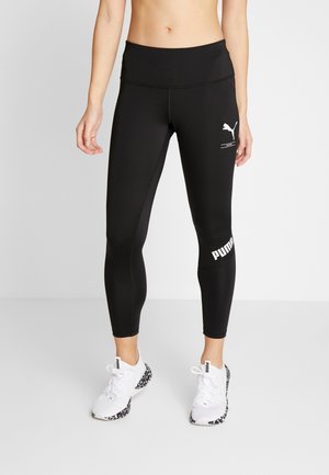 Leggings sportivi neri con vita alta, con logo Puma bianco e dettaglio nella parte bassa della gamba sinistra, realizzati in materiale elasticizzato.