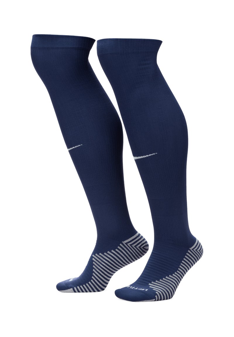 Calze blu navy alta fino al ginocchio con una texture a costine, caratterizzate da un logo argentato e un motivo a righe sul polsino e sulla suola.