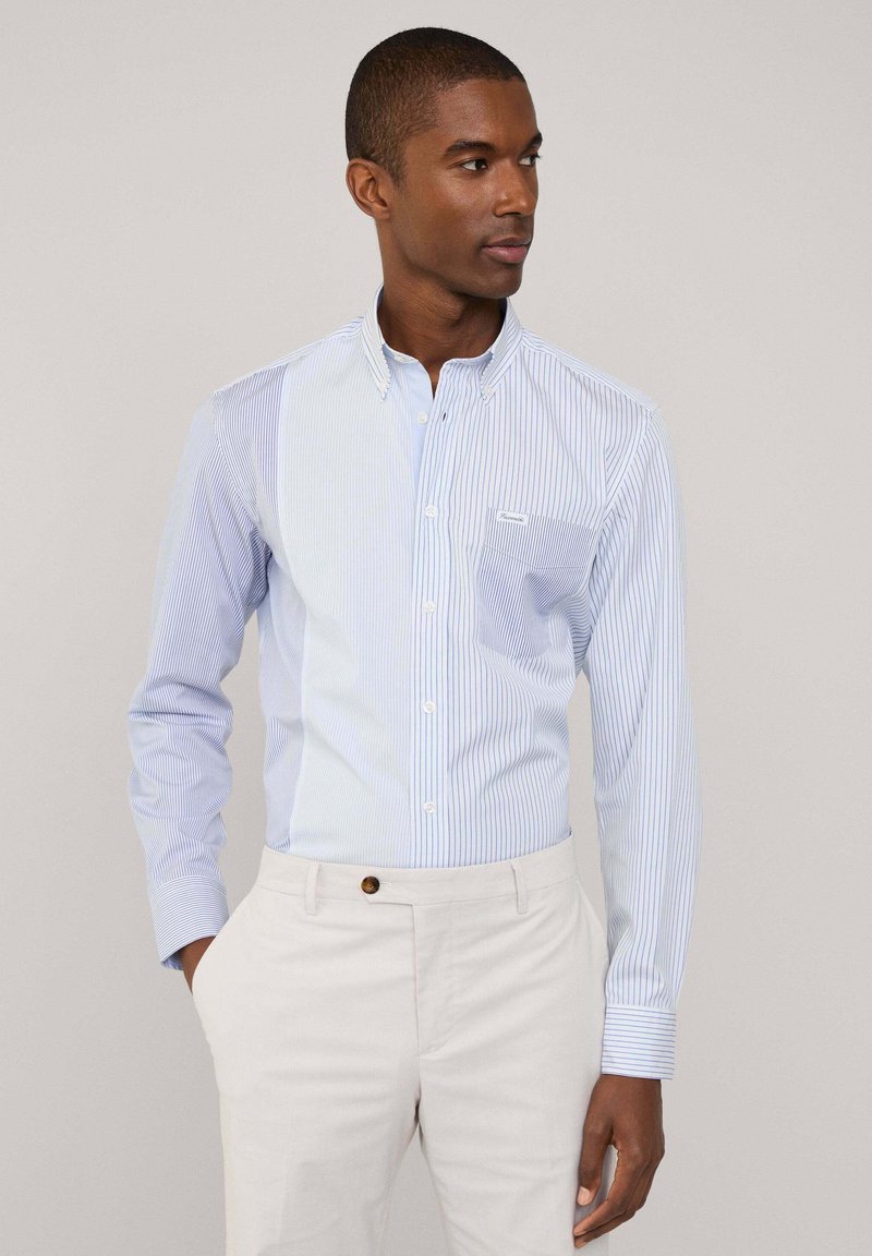Blau-weißt gestreiftes Langarmhemd mit Button-Down-Kragen und einer Brusttasche. Glattes Material, schlanker Schnitt.