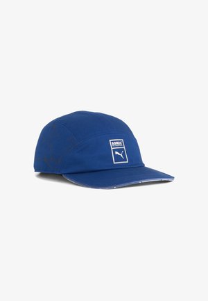 Blå Puma-cap med Sonic the Hedgehog branding, der har en subtil Sonic-siluet på siden og Puma-logoet på frontpanelet.