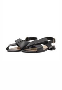 Zwarte leren platte sandalen met brede kruisschoenen, open tenen, slingback enkelbandjes en kleine geometrische hakken met gouden gespen.