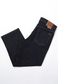 Jean en denim bleu foncé avec une coupe droite, cinq poches et une étiquette en cuir marron sur la taille arrière. Couture contrastée visible.