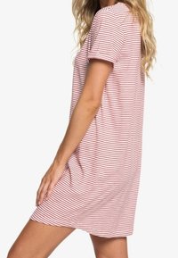 Robe rayée avec manches courtes et coupe décontractée. Confectionnée dans un tissu doux à rayures rouges et blanches, avec un col rond.