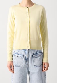 Lichtgele cardigan van zacht breimateriaal, met een ronde halslijn, lange mouwen en een knoopsluiting aan de voorkant met decoratieve knopen.