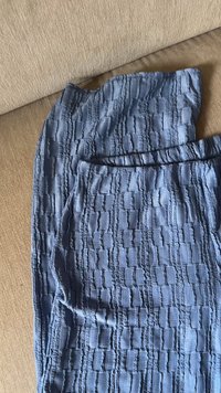 Tissu texturé bleu clair affichant un motif en grille avec de légères variations d'élévation. Matériau doux et léger, adapté à une tenue décontractée.
