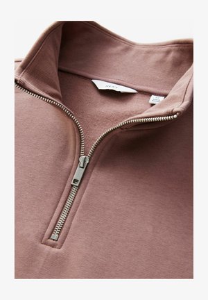 Pulover cu fermoar mediu, dintr-un material moale de culoare mauve, având un fermoar metalic, guler ribatat și o textură netedă, cu un eticheta atașată pe interior.