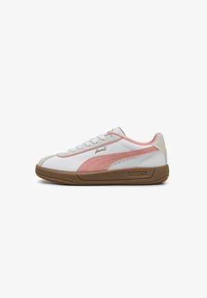 White sneakers with pink suede accents, a tan rubber sole, and a gold logo on the side. Features a classic lace-up design.