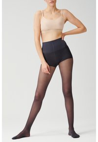 Naakte bralette met dunne bandjes, gecombineerd met transparante zwarte hoge taille panty's. De stof is glad met een matte afwerking, waardoor de silhouet wordt benadrukt.