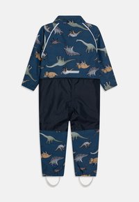 Fato de chuva infantil azul com mangas longas, apresentando um padrão de dinossauro, punhos elásticos e parte inferior em azul marinho escuro com tiras para os pés.
