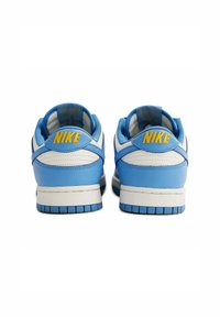Sneakers Nike con una combinazione di colori blu e bianco, realizzati in materiali in pelle e sintetici, con colletto imbottito e accento del logo giallo sul tallone.