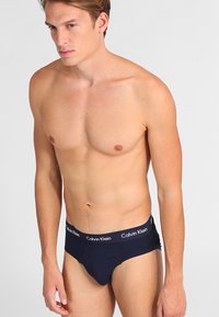 Dunkelblaue Herrenunterwäsche aus Baumwolle. Der elastische Bund trägt das Logo "Calvin Klein". Eng anliegendes Design mit glatter Textur.