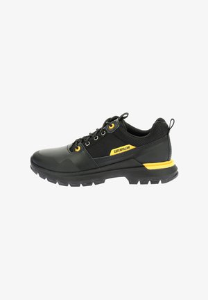 Scarpe sportive nere con accenti gialli; upper in materiale sintetico, pannelli in rete testurizzati, colletto imbottito e suola in gomma robusta.