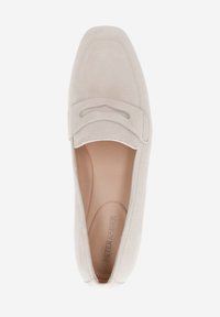 Beige suede slip-on shoe with a flat heel and rounded toe, featuring a stitched accent and smooth inner lining. Brand name embossed inside.