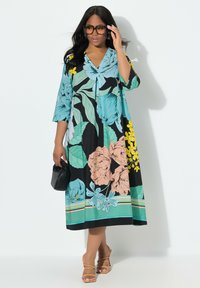 Blumenkleid mit großen, mehrfarbigen Drucken in Türkis, Schwarz und Pfirsich. V-Ausschnitt, Dreiviertelärmel und knöchellanges Design.