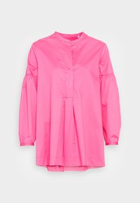 Blusa rosa a maniche lunghe con collo alto, design con pieghe nella parte anteriore e maniche arricciate. Realizzata in tessuto leggero e morbido.