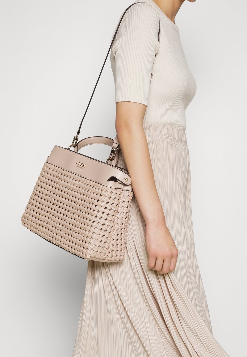 Vævet beige håndtaske med en struktureret design, dobbelt top håndtag og en aftagelig skulderrem, udstyret med et subtilt præget logo.