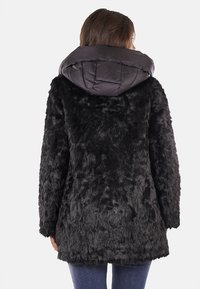 Cappotto in finta pelliccia nera con cappuccio imbottito lucido nero. Vestibilità morbida, texture soffice e maniche lunghe. Presenta un taglio di lunghezza media e senza chiusure visibili.
