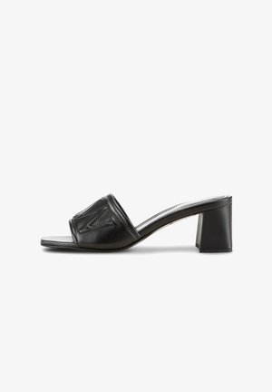 Zwarte leren sandalen met hakken, voorzien van een brede band met reliëfdetails, een open teen ontwerp en een blokhak voor stabiliteit.