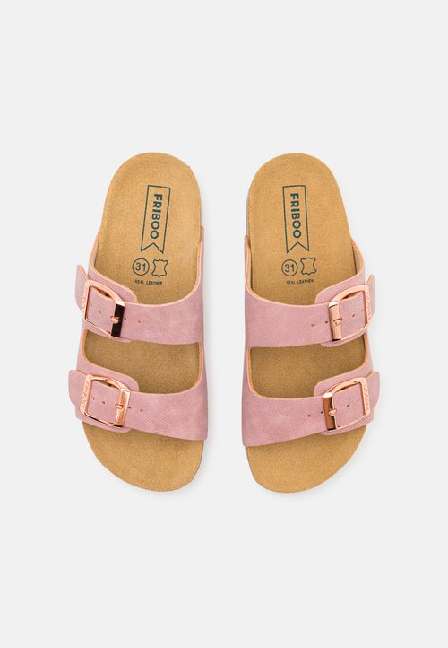 Ružové sandále na dvoch remienkoch vyrobené z semišovej kože s korokovou stielkou. Obsahujú nastaviteľné kovové pracky a plochú podrážku.