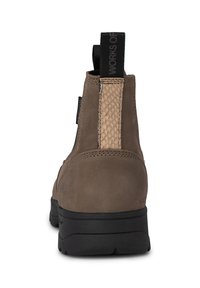 Stivaletti alla caviglia in suede marrone con un pannello in pelle intrecciata sul lato e una suola in gomma nera, dotati di linguette per facilitare l'indossamento.
