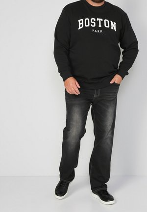 Black sweatshirt with "BOSTON PARK" printed in white, paired with faded black jeans and black sneakers with white soles. Casual attire.