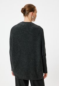 Maglione grigio scuro con una vestibilità comoda, caratterizzato da un collo rotondo, maniche lunghe e un motivo di maglia testurizzata. L'orlo arriva sotto i fianchi.