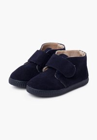 Zapatos de infante de ante azul marino con correa de gancho y bucle, punta redondeada y suela de goma negra texturizada. Forro beige suave visible.
