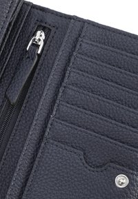 Interno di un portafoglio in pelle blu navy con multiple fessure per carte, una tasca con zip e un dettaglio a scatto argentato. La finitura texturizzata migliora la presa.