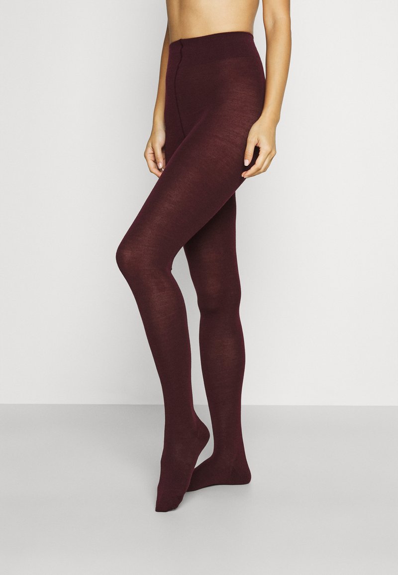 Leggings bordeaux realizzati in un materiale liscio ed elastico, con vita alta e design aderente, che coprono le gambe fino alle caviglie.