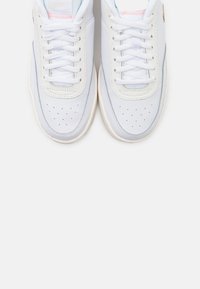 Vita sneakers med en strukturerad ovandel, ljusblå detaljer, perforerade inslag och platta snören. Har en vadderad tunga och sula.