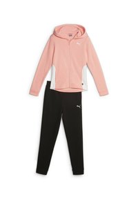 Completa sportiva Puma composta da una felpa leggera rosa chiaro con zip e dettagli bianchi, abbinata a pantaloni neri attillati. Il materiale sembra elastico e presenta una texture liscia.