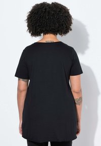 Zwarte, kortarm t-shirt met een ronde hals, met een relaxte pasvorm en een langere achterkant. Glad katoen stof zonder patronen.