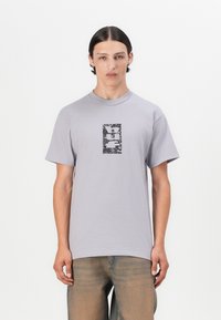 Grå bomulls t-skjorte med rund hals og korte ermer, med et svart grafisk design i midten. Glatt tekstur, avslappet passform.