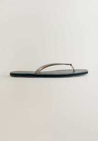 Sort flip-flop med en tekstureret fodseng, metallisk sølvstrop og kontrasterende syninger. Letvægtsbund med en glat finish.