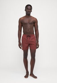 Costume de baie pentru bărbați în culoare ruginie, cu un tiv adjustable și o textură netedă, proiectat într-o formă ajustată pentru confort.