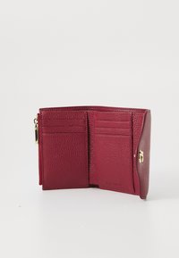 Red leather wallet with a textured surface, featuring multiple card slots and a zippered compartment. Gold hardware accents included.