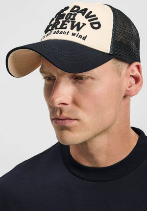 Black and beige cap with a curved visor; features bold embroidered text on the front; mesh back for breathability; structured design.