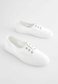 Weiße Schnürsenkel-Sneaker mit strukturiertem Obermaterial, ausgestattet mit silbernen Ösen und einer Gummisohle. Klassisches Low-Top-Design, ideal für den Alltag.