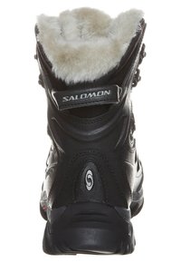 Bota de senderismo negra e impermeable con un suave collar de piel gris, parte superior de sintético texturizado, talón reforzado y detalles de logo en la parte trasera.