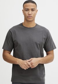 Camiseta de algodón gris oscuro con cuello redondo, mangas cortas y un corte relajado, que presenta una textura suave y detalles de costura mínimos.