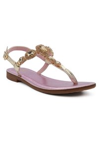 Sandalo piatto color oro con base rosa, fascia gioiello e fibbia regolabile alla caviglia. Presenta una texture liscia e un design minimalista.