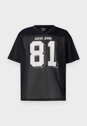 Černý síťovaný dres s krátkými rukávy, na zadní straně s bílým textem "GUESS JEANS" a výrazným číslem "81". Kulatý výstřih, volný střih.