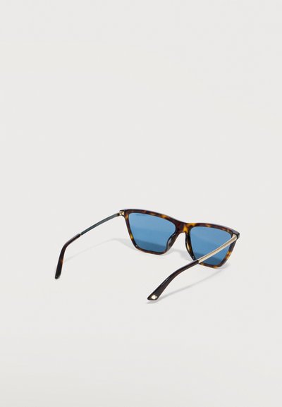 Γυαλιά ηλίου ορθογώνια με καβούκι χελώνας, με μπλε φακούς και λεπτές μεταλλικές λεπτομέρειες στα πλαϊνά, ανοιχτά πάνω σε λευκή επιφάνεια.