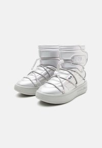 Hvite høyde sneakers med en glatt syntetisk overdel, polstret krage, elastiske lisser og en tykk gummisåle med minimal merkevare.