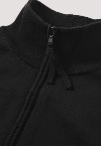 Schwarzer Reißverschluss-Pullover mit hohem Kragen, aus Strickstoff gefertigt. Verfügt über einen kleinen Reißverschluss-Schieber und eine strukturierte Naht am Kragenrand.