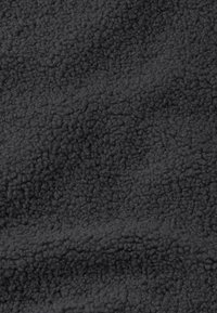 Zwarte fleece stof met een zachte, textuur oppervlak. Het materiaal heeft een pluche, krullend patroon, ideaal voor warmte en comfort.