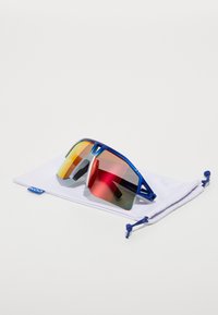 Lunettes de sport bleues avec des verres réfléchissants orange et rouges, dotées d'un design élégant et d'une pochette blanche protectrice pour le rangement.