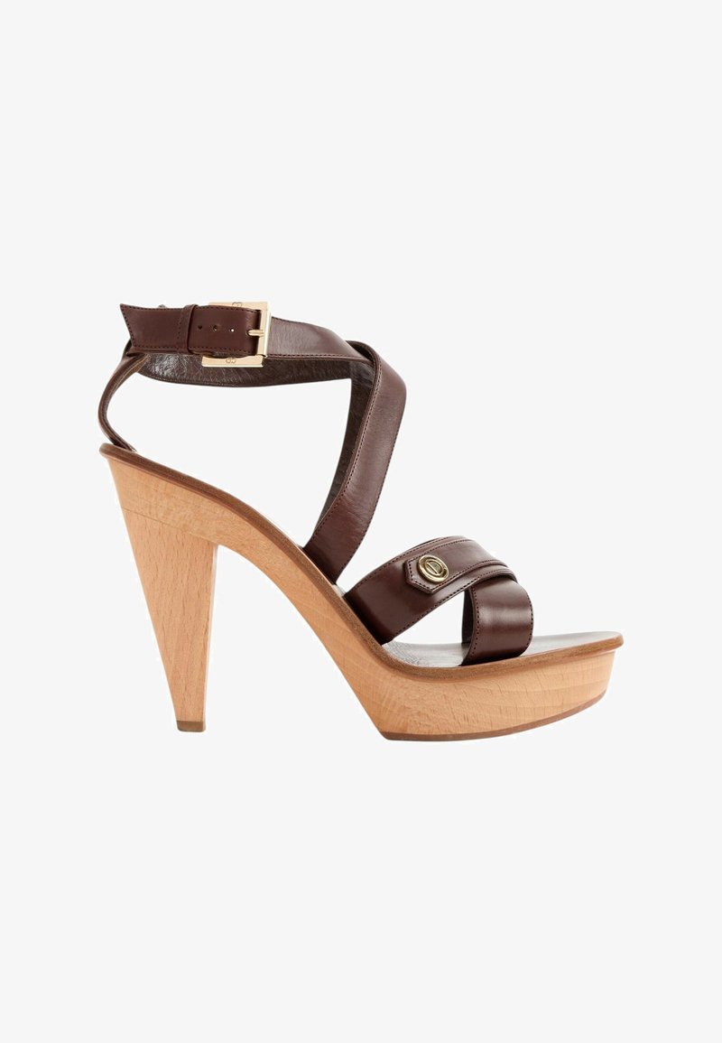 Sandale à talon haut avec plateforme et talon en bois, avec des brides en cuir marron foncé et une boucle dorée autour de la cheville.