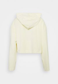 Sudadera corta amarilla de tela suave con mangas largas y capucha ajustable. Presenta costuras mínimas y sin logotipos visibles.