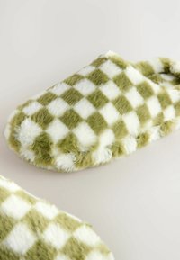 Green and white checkered fuzzy slippers with a soft texture and rounded shape, designed for indoor comfort.